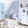 Kinderzimmer mit blauer Vliestapete mit Sternenmuster, passend zu Möbeln und Deko.