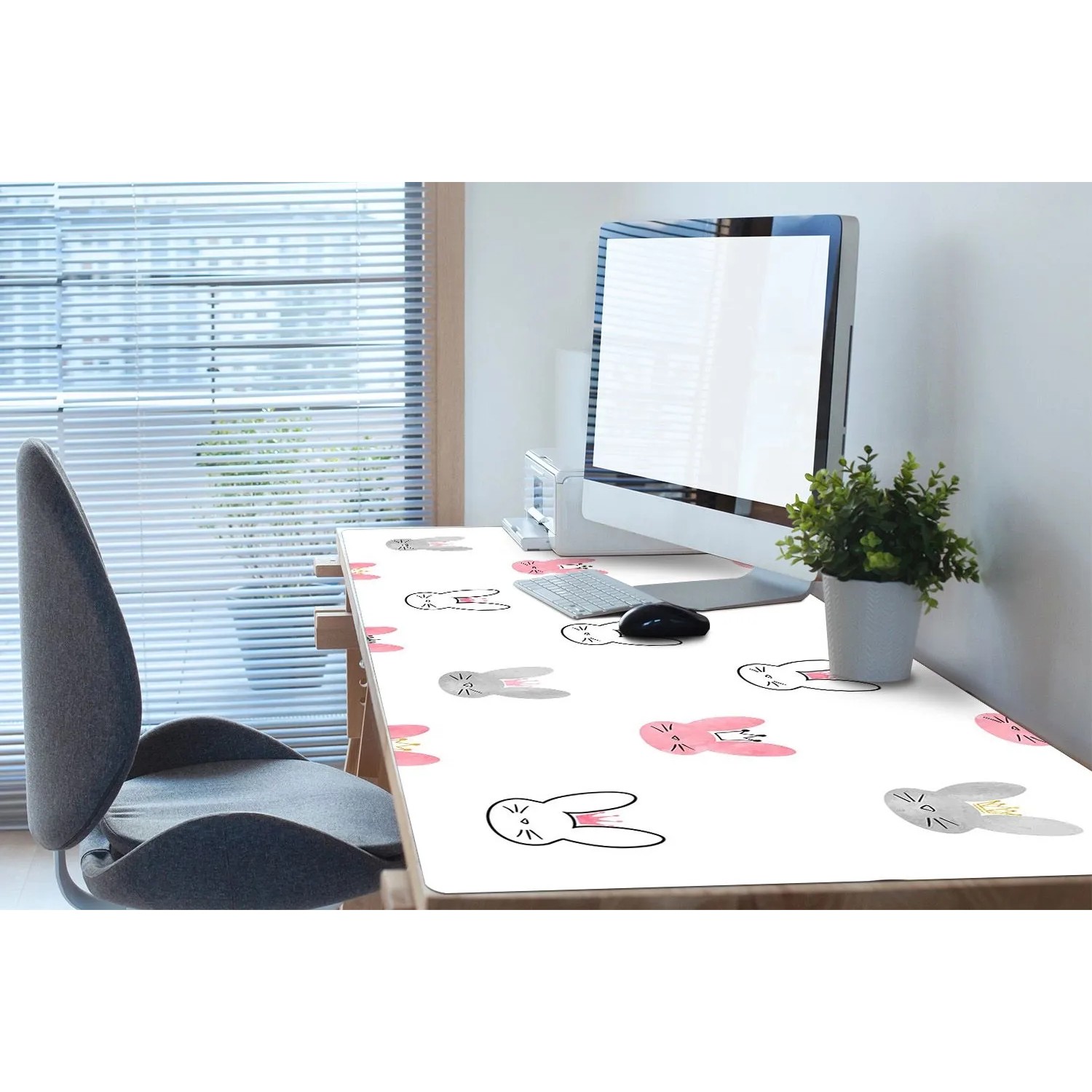 Rosa PVC Schreibtischunterlage mit niedlichen Kaninchen und Kronen auf einem Bürotisch mit Computer.