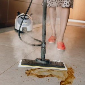 Kärcher Dampfreiniger SC 5 EasyFix Iron Plug im Einsatz auf Fliesenboden mit Schmutz.
