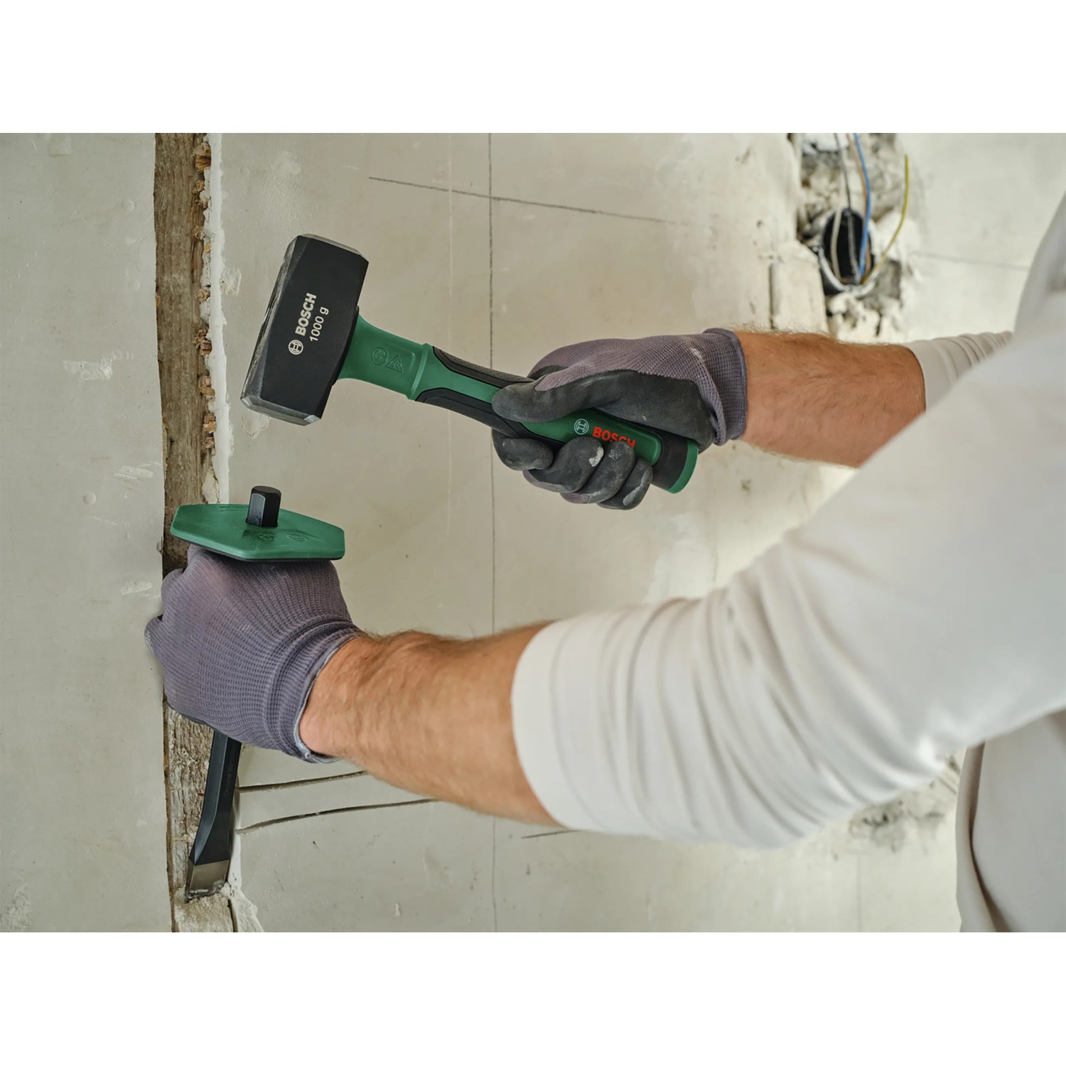 Anwendung des Bosch Steinmeißels flach 22 mm mit Hammer zum Stemmen in einer Wand.