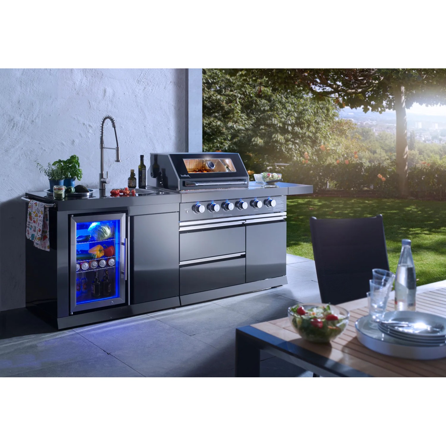 Buschbeck Outdoorküche Cambridge mit Gasgrill, Spüle und Getränkekühlschrank im Garten.