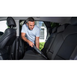 Mann reinigt Autositz mit Shark Akku-Handsauger WV200EU. Handstaubsauger für Auto.