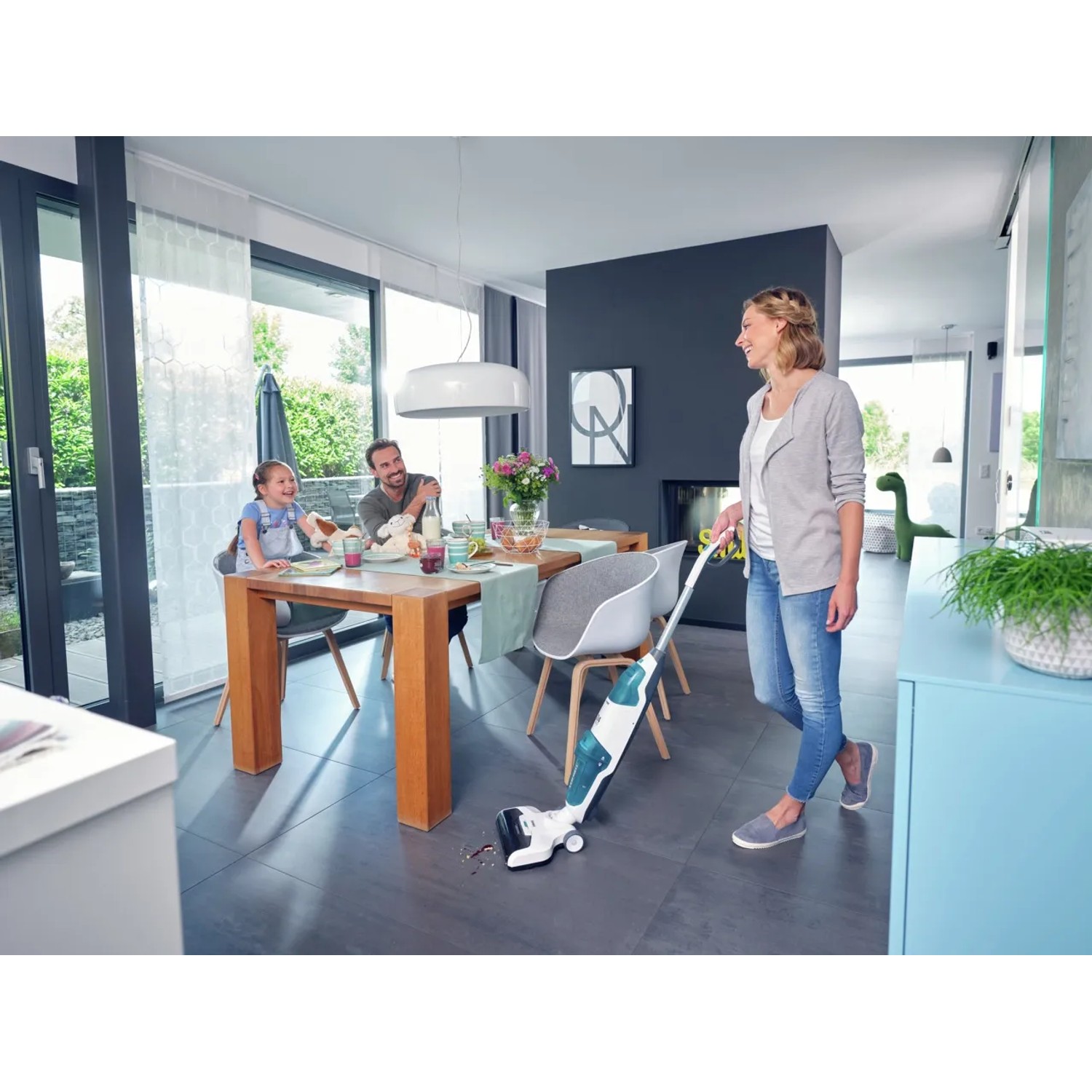 Frau nutzt Leifheit Akku-Saugwischer Regulus Aqua PowerVac im Wohnbereich.