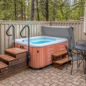 Graue Monstershop Whirlpool Abdeckung, teilweise geöffnet, mit Holzverkleidung und Treppe.