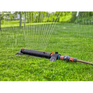 Gardena Viereckregner AquaZoom L in Aktion: Bewässerung eines grünen Rasens.