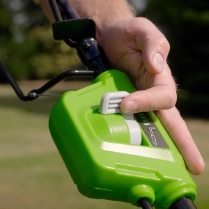 Detailaufnahme des Greenworks Akku-Rasenmähers GD40LM46SP: Hand betätigt Schalter.