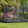 Schwarzes Salta Bodentrampolin Comfort Edition 366x244 cm mit Sicherheitsnetz und springendem Kind.