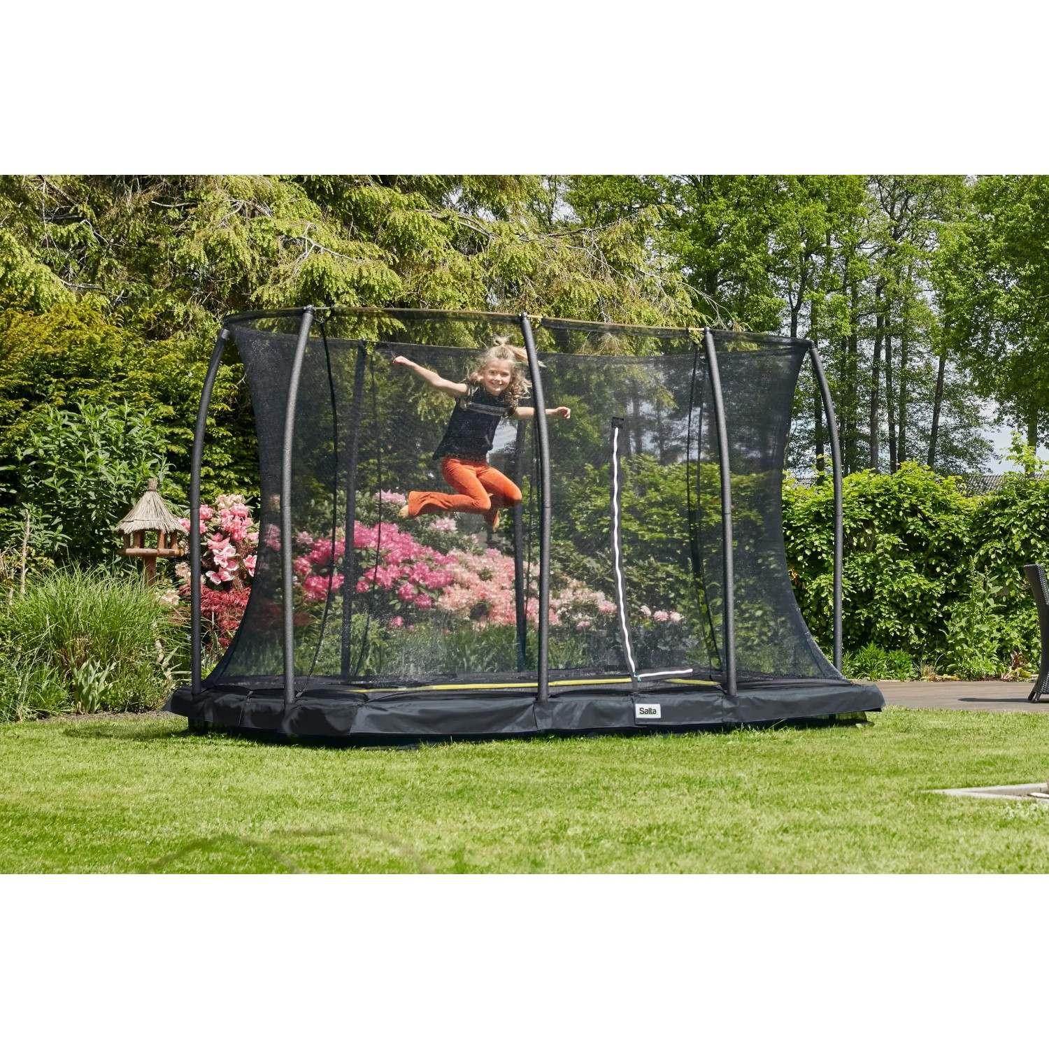 Schwarzes Salta Bodentrampolin Comfort Edition 366x244 cm mit Sicherheitsnetz und springendem Kind.