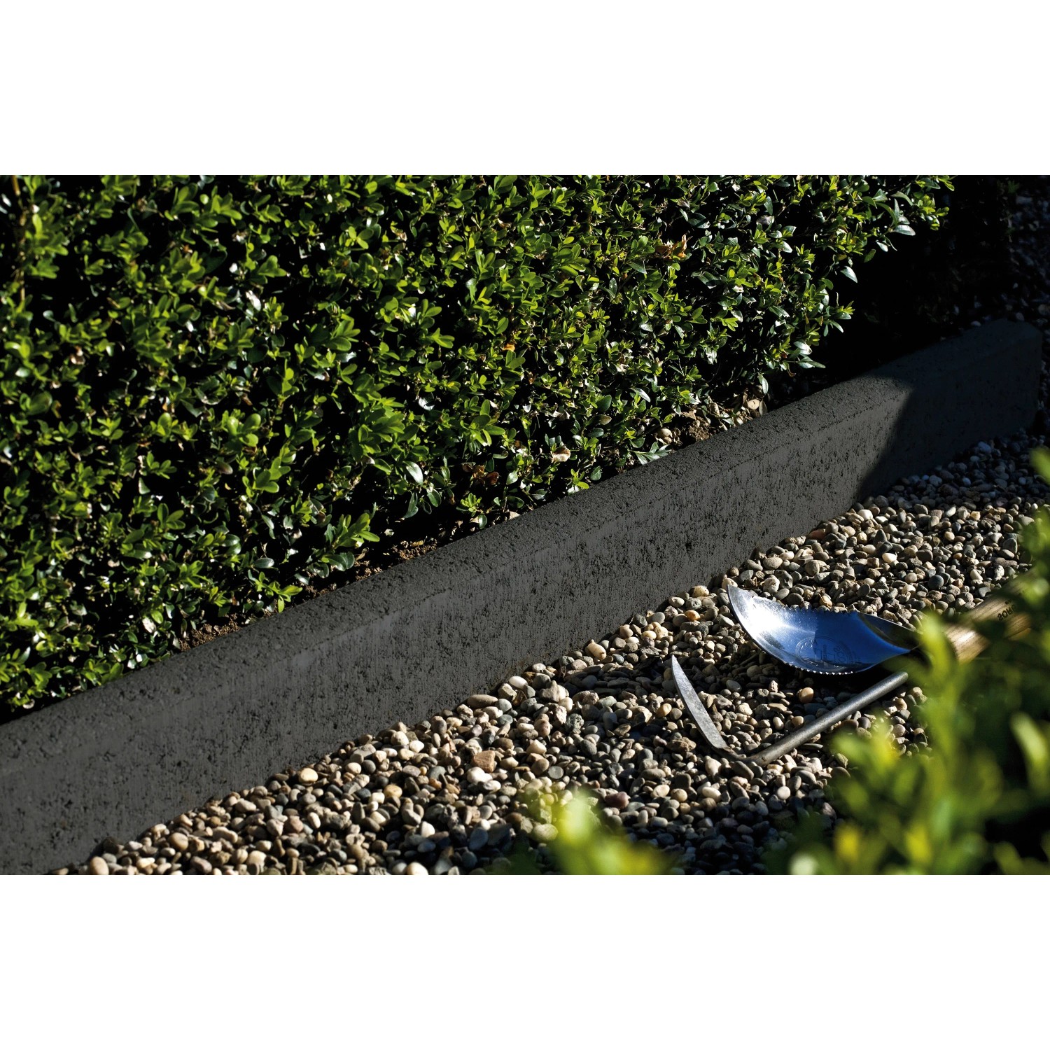 Anthrazit Tiefbordstein (100x30x5 cm) als Beeteinfassung im Garten.