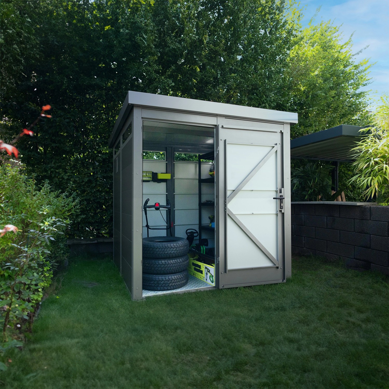 Modernes graues Amazing Spaces Gartenhaus Shape im Garten, Tür geöffnet, mit Reifen und Gartengeräten.