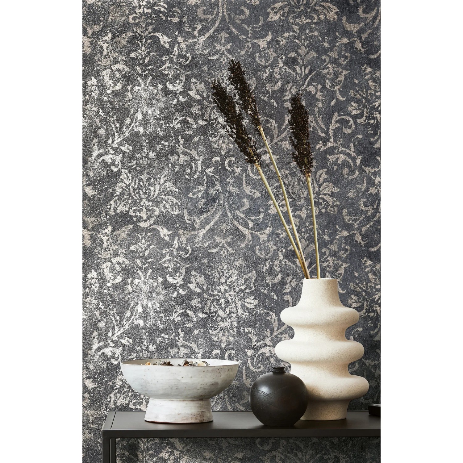 Marburg Vliestapete Betonoptik in Schwarz-Silber mit floralem Muster und Deko-Elementen.