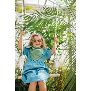 Fröhliches Kind auf Holzschaukel des small foot Schaukel-Sets 3 in 1, umgeben von grünen Pflanzen.