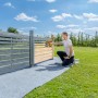 Mann sprüht mit Wagner Akku-Farbsprühsystem W 600 FLEXiO einen Holzzaun im Garten.