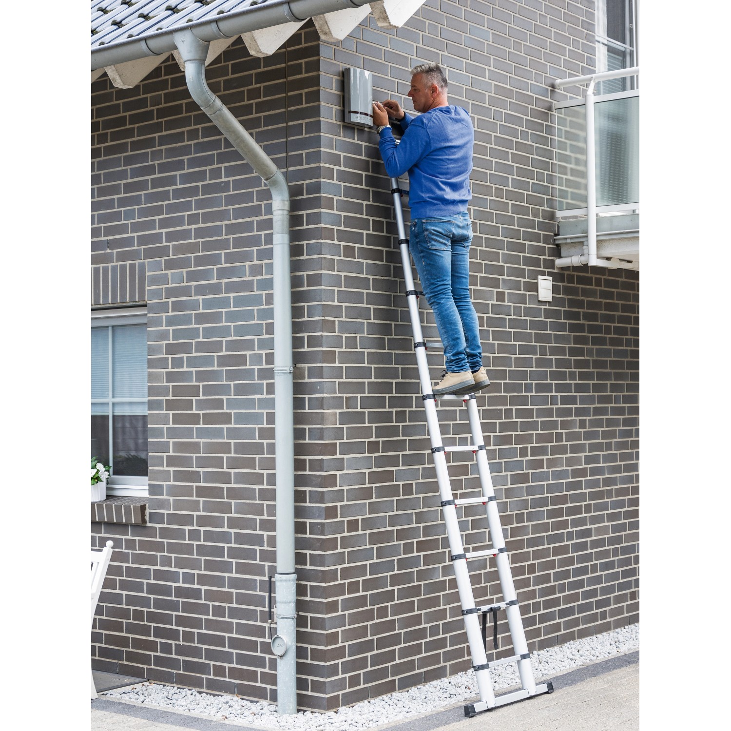 Aluminium Teleskopleiter mit 11 Stufen im Einsatz an einer Hauswand. Arbeitshöhe 3,25 m.