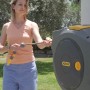 Frau zieht Gartenschlauch aus Hozelock Schlauchtrommel Auto Reel. 30m Schlauch, automatische Aufrollung.
