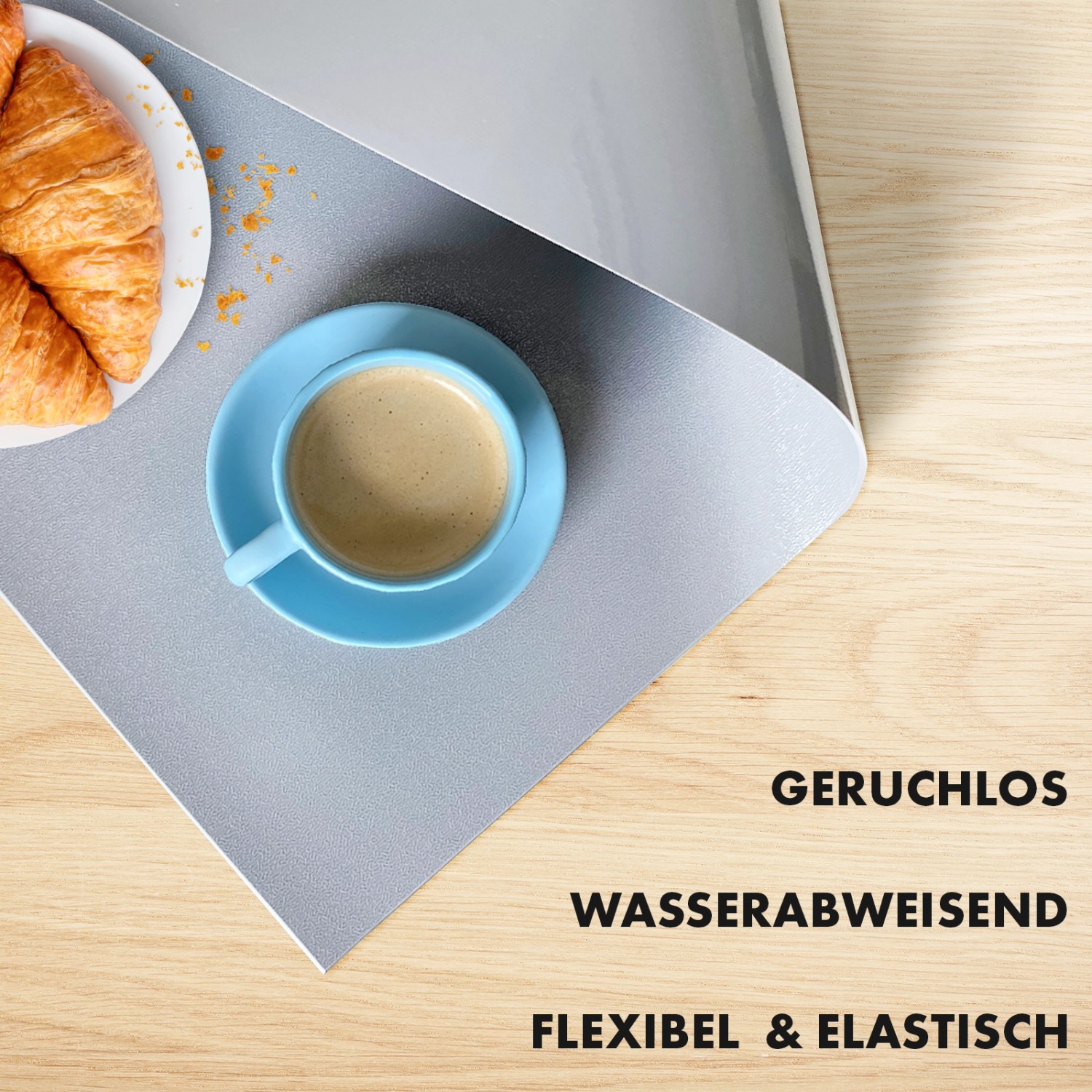Hellgraue KARAT Tischfolie Empire (80x185cm) mit abgeschrägter Kante, mit Kaffee und Croissant.
