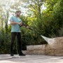 Mann reinigt Steinmauer mit Kärcher K 6 Flex Home Hochdruckreiniger im Garten.