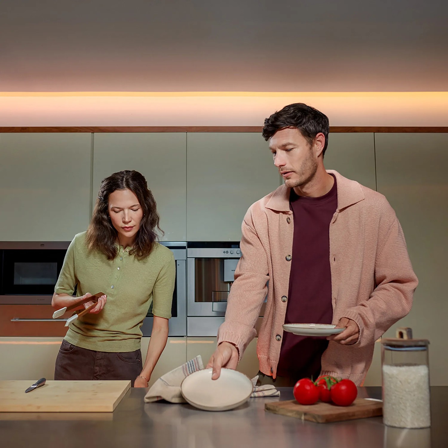Paar in Küche mit Philips Hue Lightstrip für stimmungsvolle Beleuchtung.