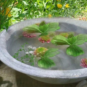 Graue Deko-Schale (Ø 35cm) mit Wasser und Dekoration im Garten.