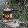 Petromax Feuerpfanne FP15H-T auf Kocher im Freien beim Kochen. Gusseisenpfanne mit Stiel.