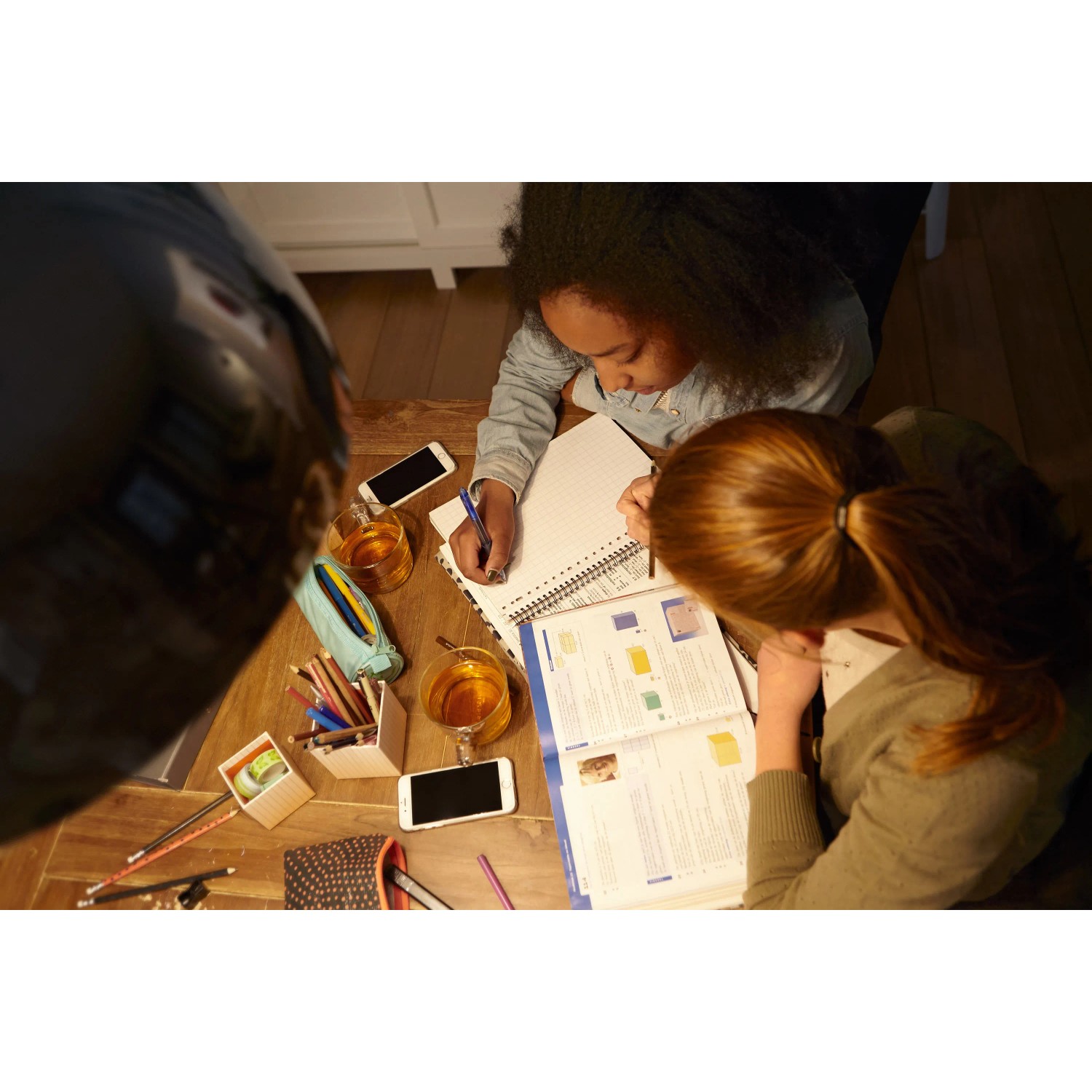 Zwei Kinder lernen am Tisch unter dem Licht einer Philips LED E27 Glühbirne.