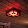 Quadratische Philips Hue Econic LED-Wandleuchte mit Farbwechsel, montiert an einer Holzdecke.