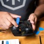 iFixit Anti-Clamp Öffnungswerkzeug in Aktion an einem Smartphone mit Glasbruch.