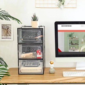 Songmics Schuhkarton, 3 transparente Boxen in Schwarz, gestapelt auf einem Schreibtisch.