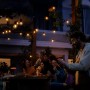 Gruppe feiert unter der Philips Hue Festavia Lichterkette mit warmem Licht im Garten.