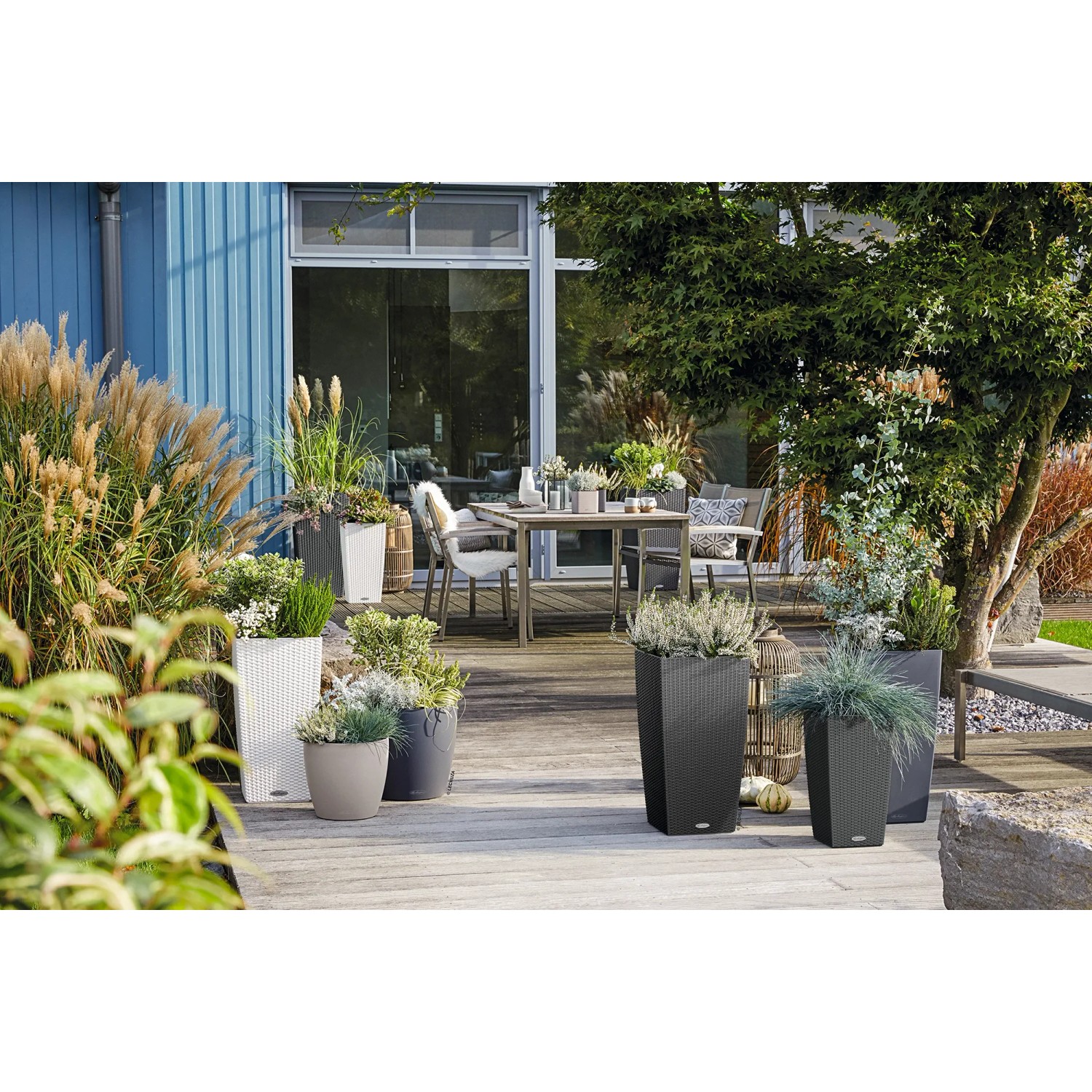 Lechuza Cubico Cottage 30 Pflanzkübel in Granit auf einer Terrasse mit Gartenmöbeln.