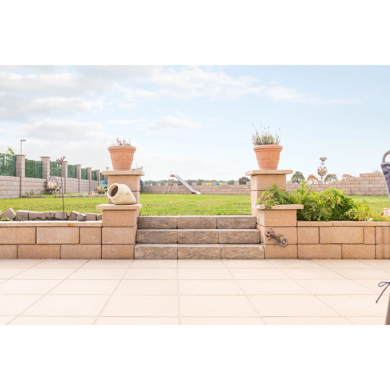 Diephaus Mauer Canta Normalstein Sandstein als Garteneinfassung mit Treppe und Bepflanzung.