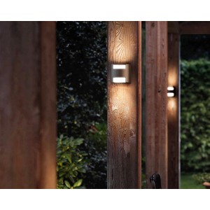 Anthrazitfarbene Philips LED-Außenwandleuchte Grass an Holzpfosten.