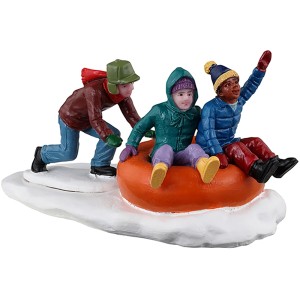 Lemax Weihnachtsfigur: Drei Freunde beim Tubing auf einem orangefarbenen Reifen im Schnee.