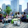 Szene mit Elho Blumentopf Loft Urban Ø 70 cm (weiß) auf einer Dachterrasse mit Menschen.