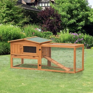 Brauner Kaninchenstall aus Tannenholz mit grünem Asphaltdach und vergittertem Freilaufgehege für Kleintiere im Garten.