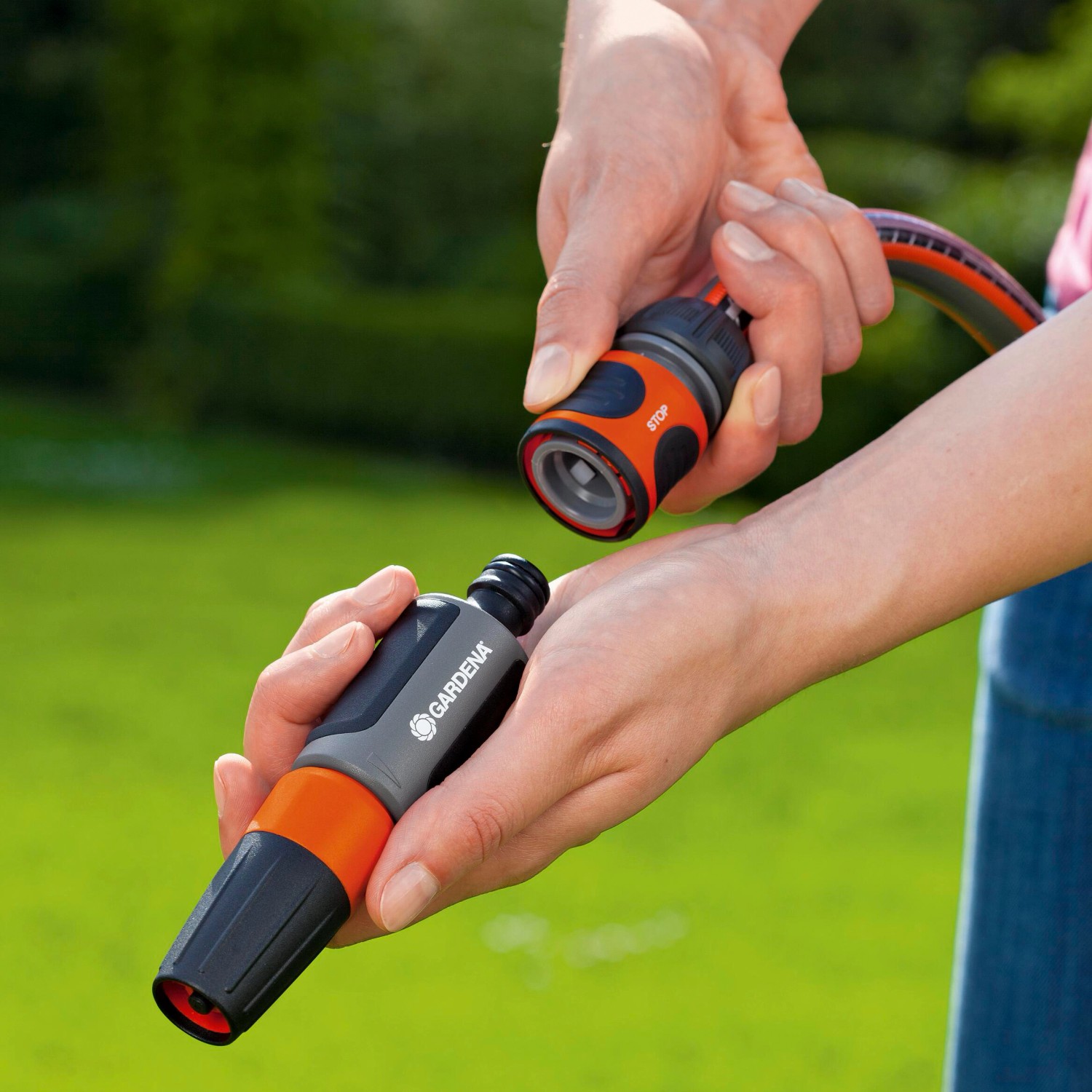 Gardena Schlauchverbinder-Satz (13-15mm) in Aktion: Schlauchanschluss und Wasserstop in Händen.