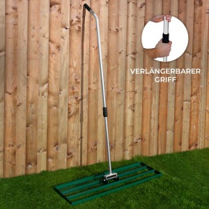 Grüner Monstershop Rasenrakel (100cm) mit ausziehbarem Griff vor Holzzaun.