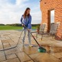 Frau reinigt Terrasse mit Bosch Aquasurf 280 Flächenreiniger. Schwenkbarer Kopf für einfache Handhabung.