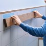 Anwendung: Tesa Montageband für Fliesen und Metall hält Holzleiste an Wandfliesen.
