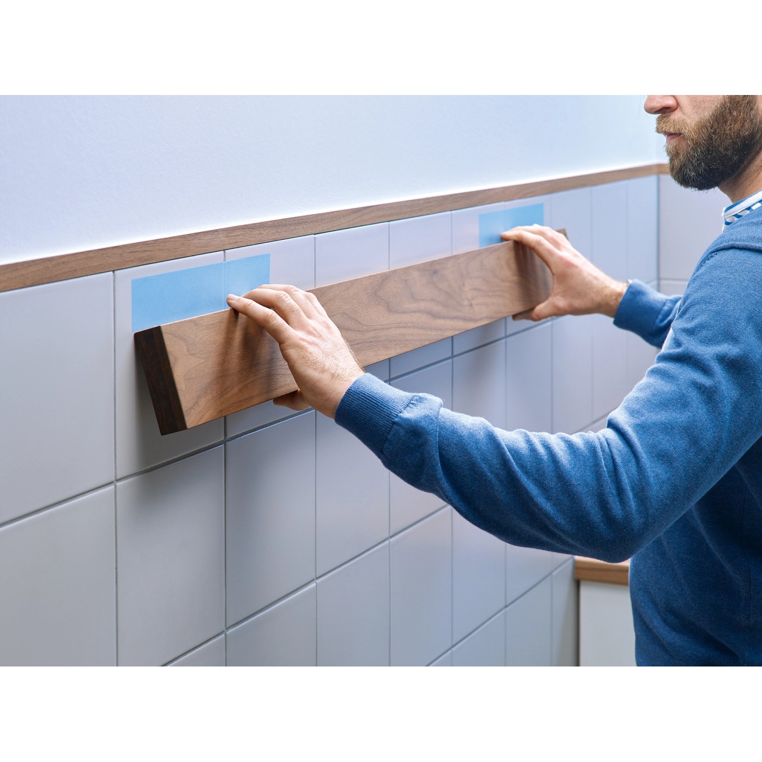 Anwendung: Tesa Montageband für Fliesen und Metall hält Holzleiste an Wandfliesen.