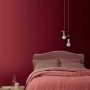Schlafzimmer mit Wandfarbe Velvetine No. 442 von ELLE DECORATION in Mattrot.