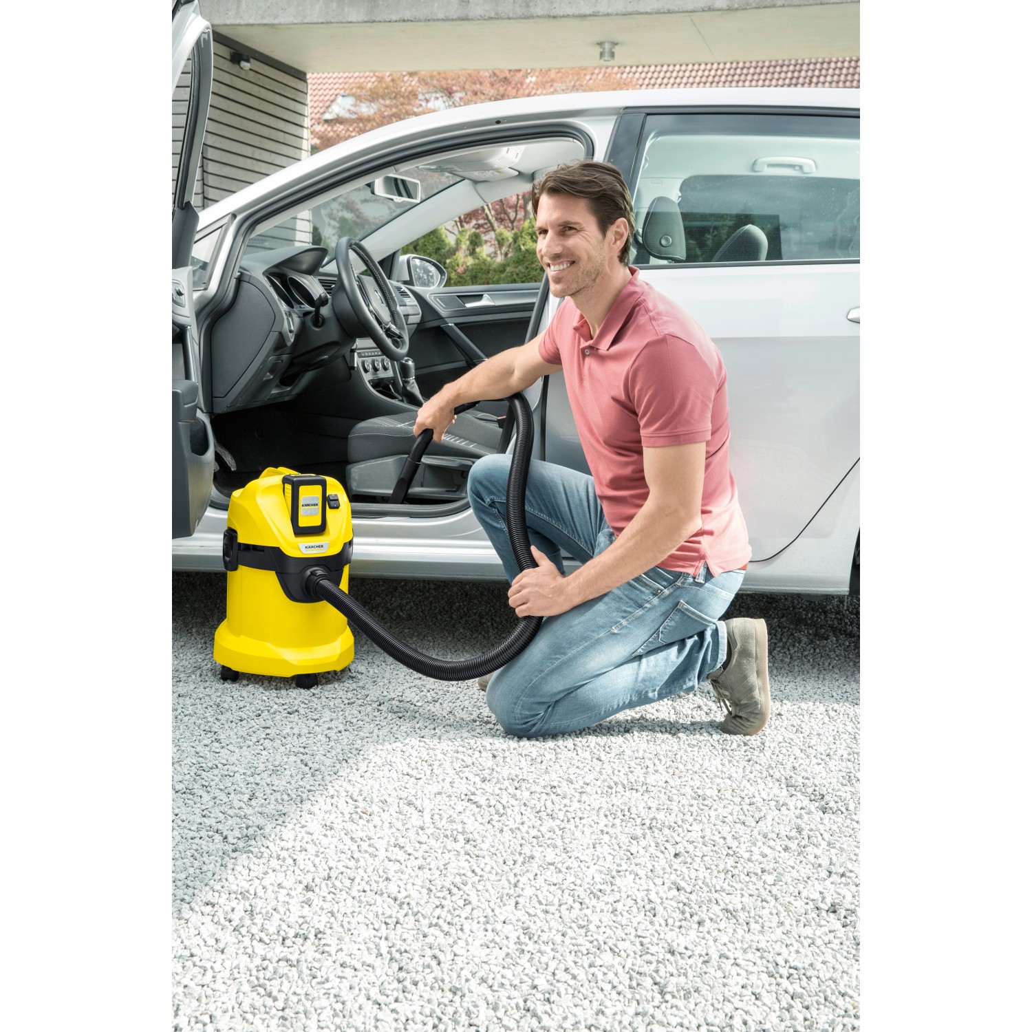 Gelber Kärcher Akku-Mehrzwecksauger WD 3 beim Reinigen eines Autoinnenraums.