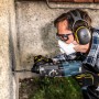 Mann bohrt mit 3M Peltor Kapselgehörschutz X2A; effektiver Gehörschutz für Heimwerker.
