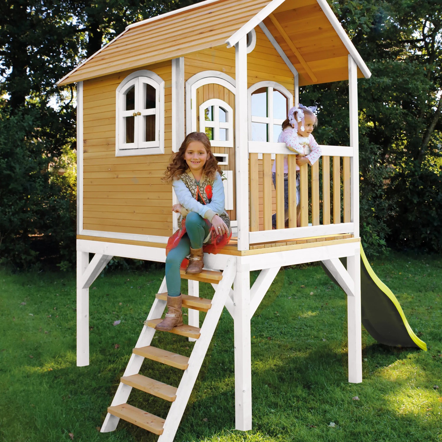 Axi Spielhaus Laura mit Rutsche, braun/weiß, mit zwei Kindern. Das Holzspielhaus ist FSC® zertifiziert.