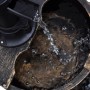 Detailaufnahme: Kaskadenbrunnen im Vintage-Design mit Handwasserpumpe und fließendem Wasser.