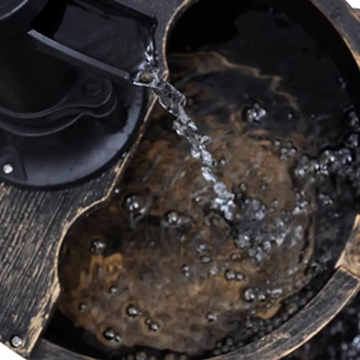 Detailaufnahme: Kaskadenbrunnen im Vintage-Design mit Handwasserpumpe und fließendem Wasser.