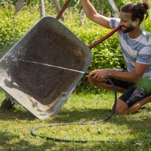 Mann reinigt Schubkarre mit Gardena Haus- und Gartenautomat 4600 Silent.