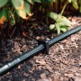 Geka Drip Rohrhalter Erdspieß (10 Stk.) fixiert ein schwarzes Tropfrohr im Gartenboden.