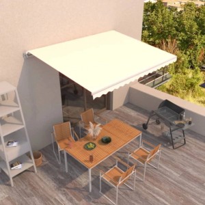 Cremefarbene, manuell einziehbare Markise über einer Terrasse mit Möbeln. Bietet Sonnenschutz für den Außenbereich.