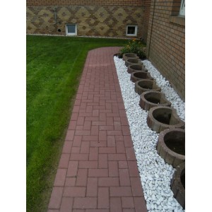 Verlegter, roter Rechteck-Pflasterstein aus Beton (20x10x8 cm) als Gartenweg.